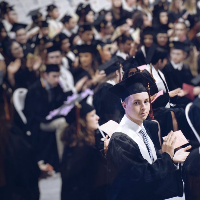 Young man clapping at graduation ceremony